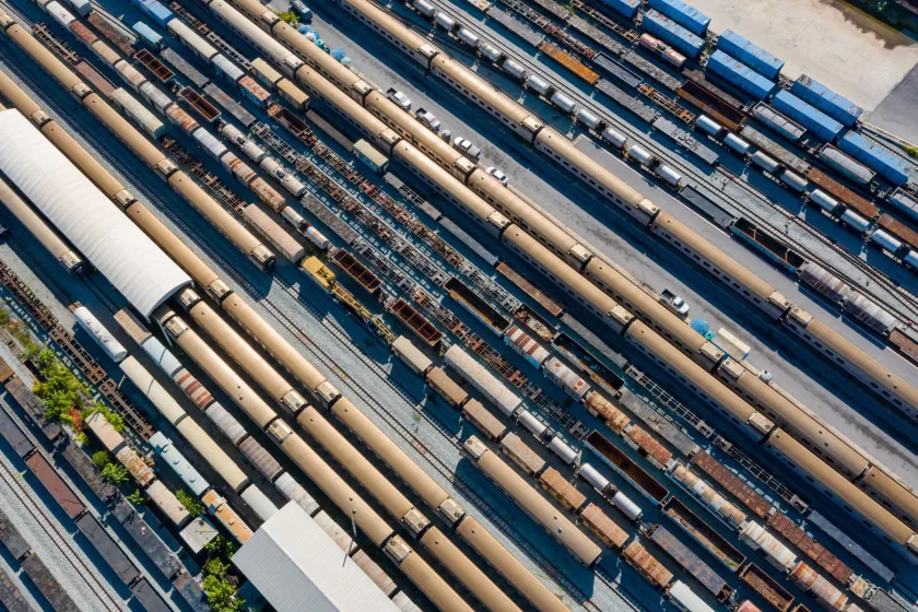 Overhead view of a railway yard packed with rows of passenger and freight cars on parallel tracks