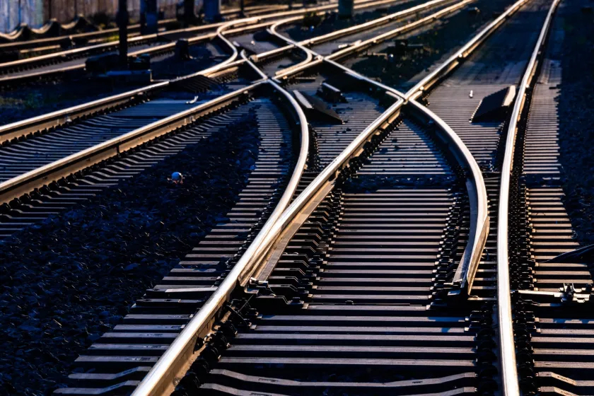 Railway tracks crossing through switches and points, rails gleaming in sunlight